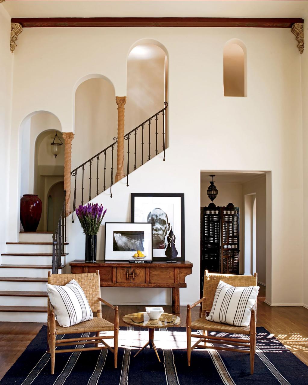 on the wall, photographs by sebastiao salgado are displayed on an antique chinese painters table in the living room and the 1950s lacquer side table by osvaldo borsani is from jf chen the chairs are vintage and the pillows are made from indian cotton throws