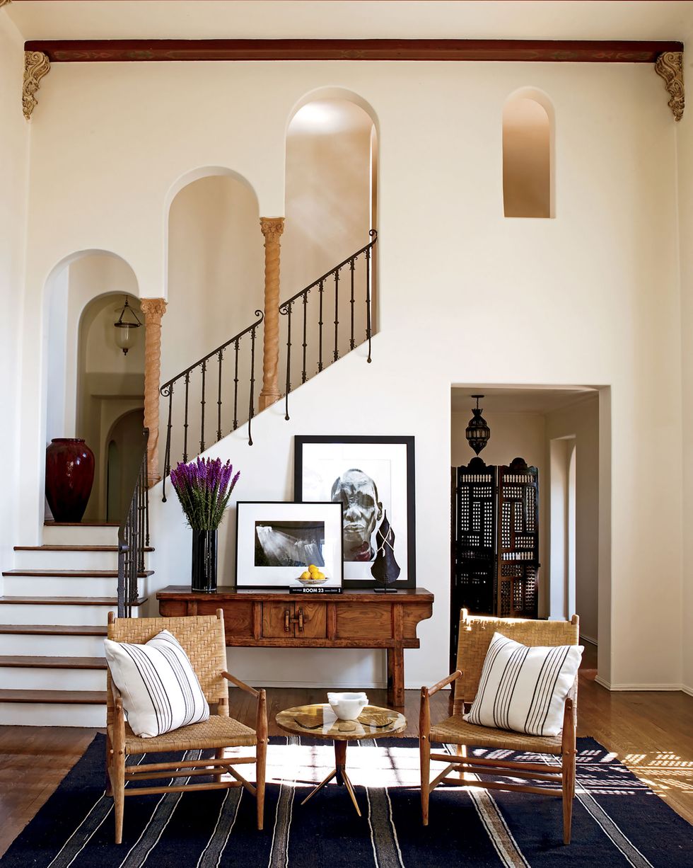 on the wall, photographs by sebastiao salgado are displayed on an antique chinese painters table in the living room and the 1950s lacquer side table by osvaldo borsani is from jf chen the chairs are vintage and the pillows are made from indian cotton throws