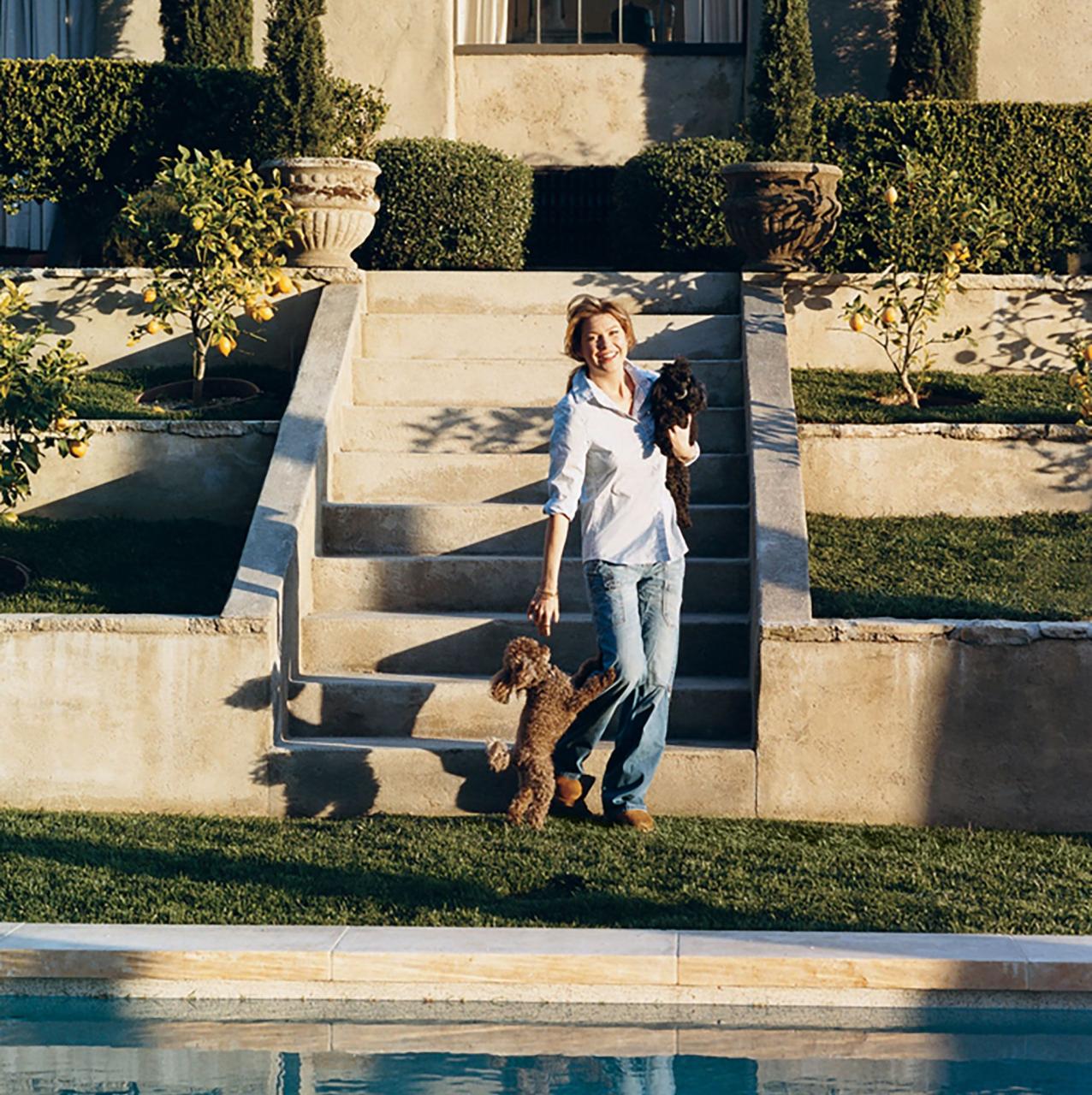 ellen pompeo plays with her toy poodles gigi and valentin, beside the swimming pool at her home in the hollywood hills