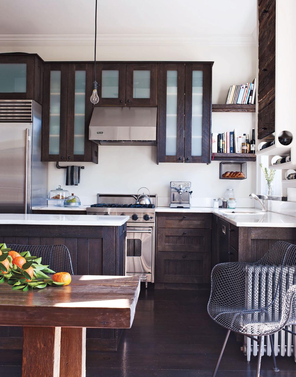 the kitchen cabinet­ry and island are made of espresso stained reclaimed fir the refrigerator is by sub zero, and the range and vent hood are by viking the sink fittings are by grohe and the light fixture is by rejuvenation