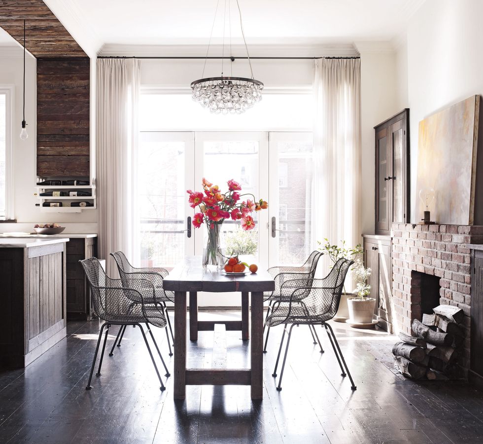 wire chairs from abc carpet and home surround a pine table in the dining room the curtains are of a larsen wool and the pine floors are original