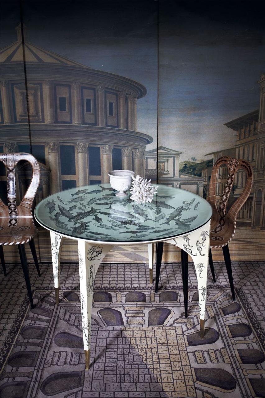 a table with a glass top and chairs on a brick patio