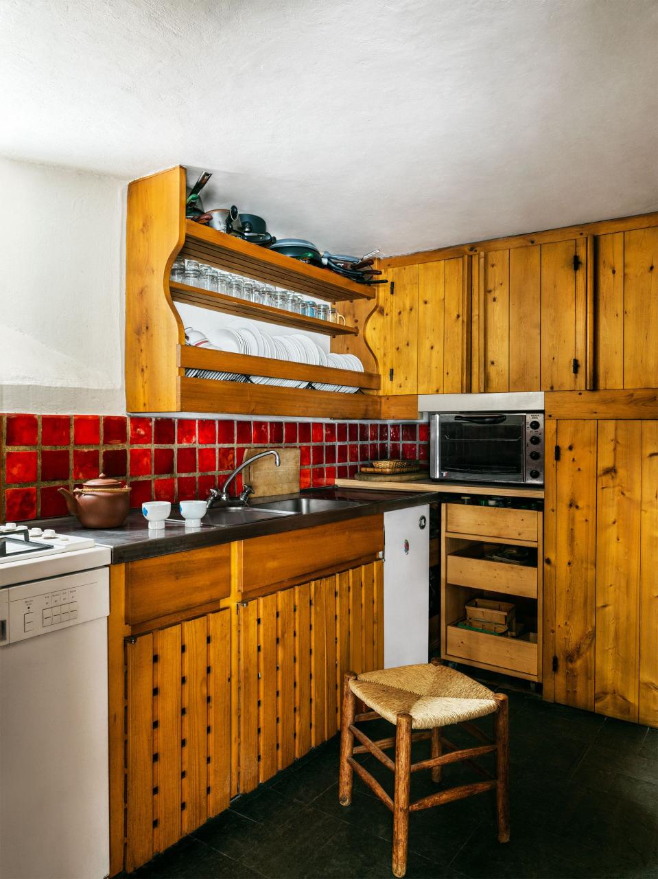 small wood paneled kitchenette with red tile backsplash