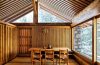 spare wood paneled room with simple dining table and chairs at center