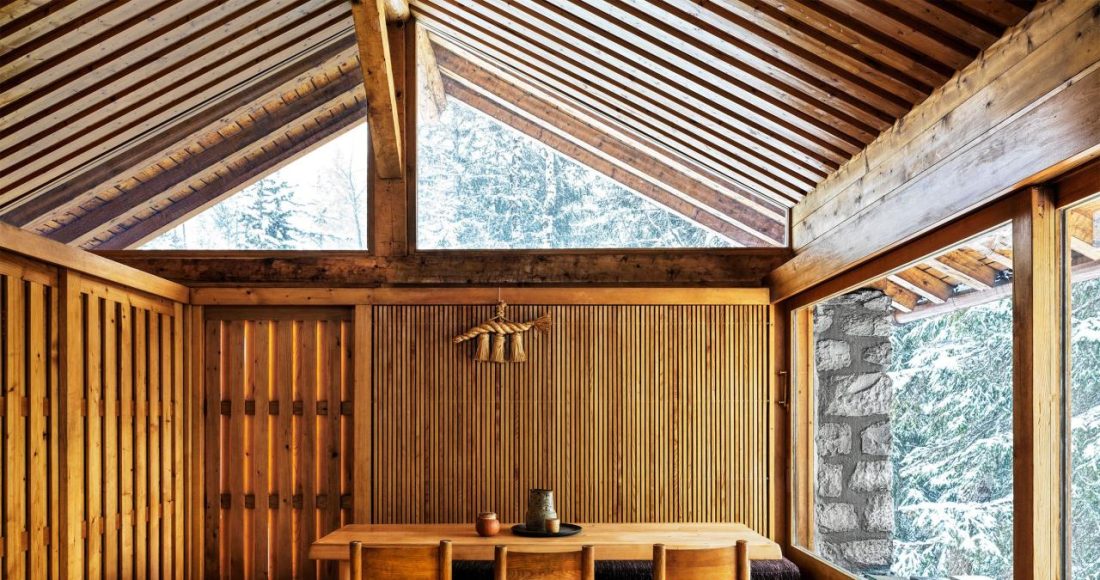 spare wood paneled room with simple dining table and chairs at center