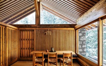 spare wood paneled room with simple dining table and chairs at center