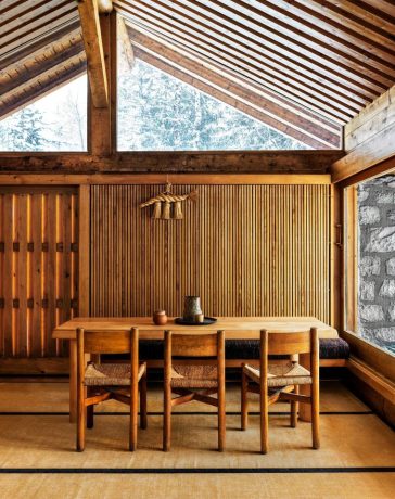 spare wood paneled room with simple dining table and chairs at center