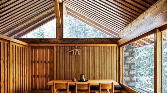 spare wood paneled room with simple dining table and chairs at center