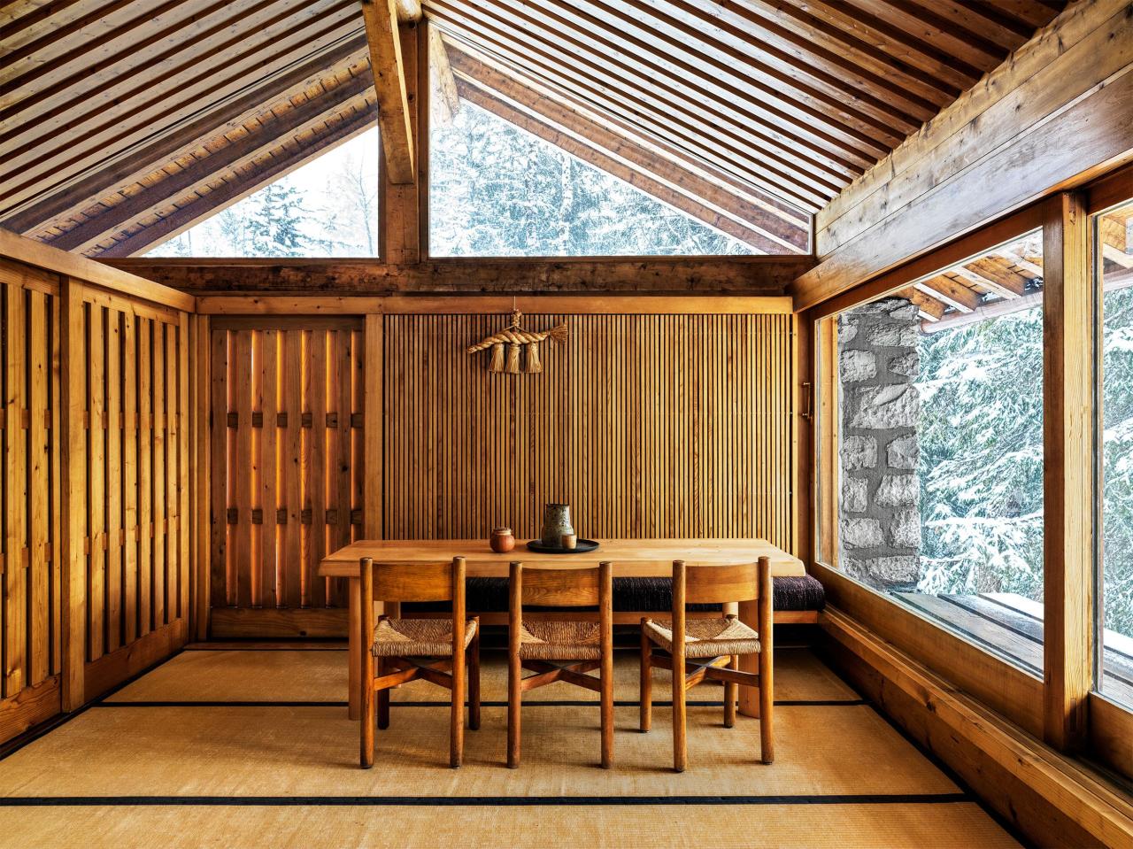 spare wood paneled room with simple dining table and chairs at center