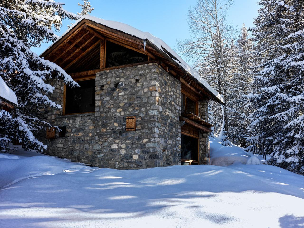 exterior of stone house with wooden gables surrounded in a snowy landscape