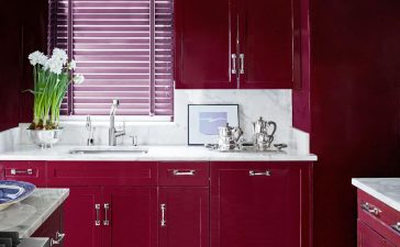 kitchen with red cherry cabinets and white marble counters and black and white geometric floor