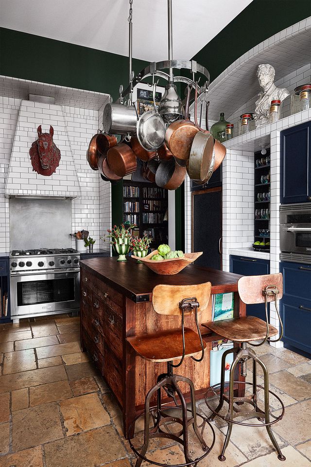 kitchen with rustic wood counter and stools with wood bodies and metal legs and white tiled walls