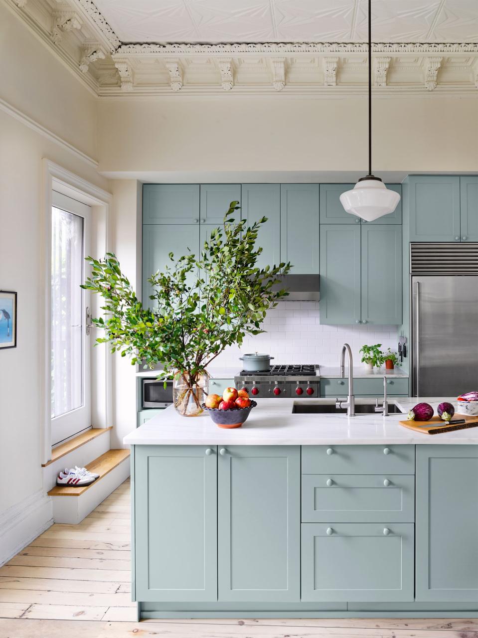 kitchen with light plank flooring and light greenish blue cabinetry and white countertops