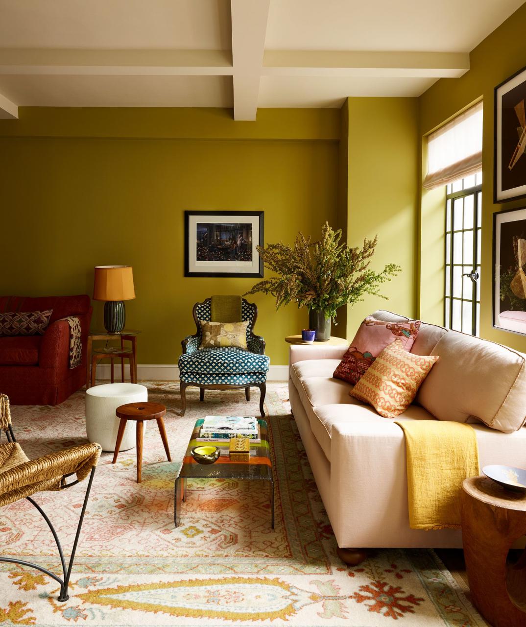 a chartreuse yellow room with a wood side table and chairs and artwork