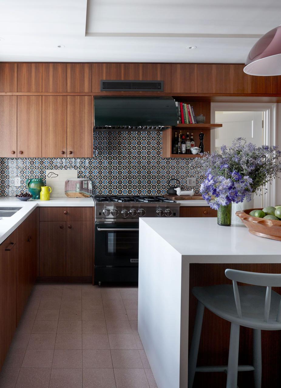 kitchen with colored backsplash and sleek wood cabinetry and white island